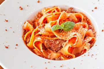 Italian pasta with sauce and parmesan cheese, served on a white 