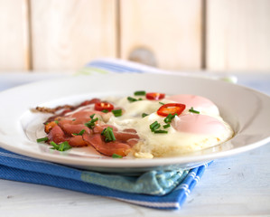 Ham and eggs on white plate