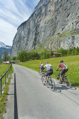 Fototapeta premium Bike Riders in Country road in Lauterbrunnen valley, Swiss