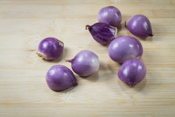 Shallots (red onion) set up on wood table