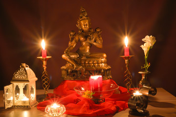 Indian religious culture of home decoration of ritual lights with statue and lit candles 
