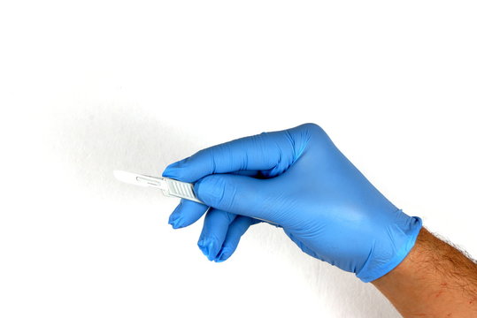Hand with blue surgical glove and scalpel