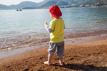 Cute boy playing and having fun on the beach