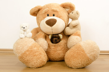 A family of teddy bears, big bear protecting the smaller ones, bear toys