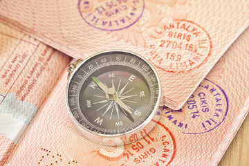 On the page of passports with visas lies with the compass