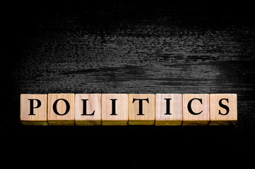 Word POLITICS isolated on black background