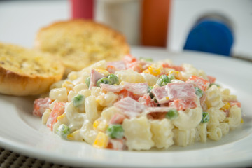 Macaroni salad with mayonnaise and vegetables.