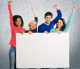 Volunteer. Large group holding a big white board.
