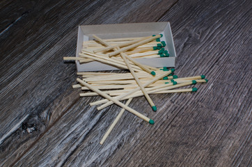 matches in the box and scattered on the wooden background