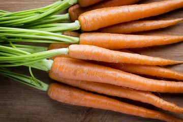 Fresh carrots on the wooden background.
