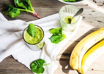 Vitamin green smoothie with spinach leaves, banana and peanut mi