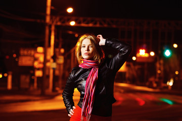 Fototapeta na wymiar A beautiful glamour girl in jacket is standing in the city stree