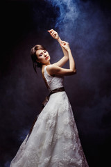 A beautiful bride in luxury wedding dress is posing with raised © Mayatnikstudio