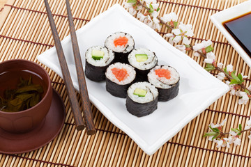 Sushi maki set, green tea and sakura branch