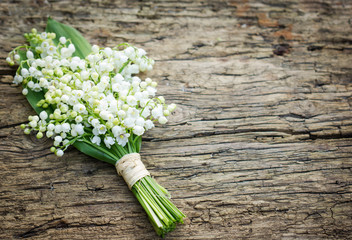 Bouquet of lilies of the valley on the wooden board - obrazy, fototapety, plakaty