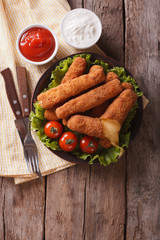 fried cheese with sauce on a plate. vertical top view