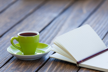 Cup of coffee and notebook with pencil