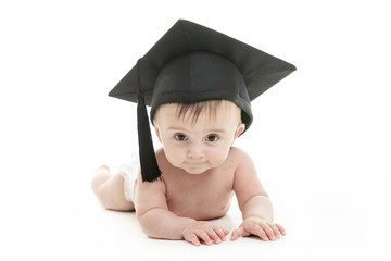 Portrait of a sitting baby with a graduation cap