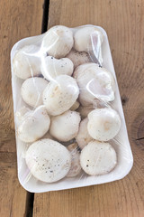 Mushrooms  packed in cellophane on wooden table