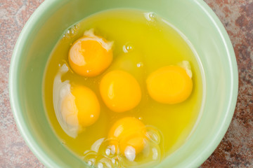 raw cracked eggs in bowl