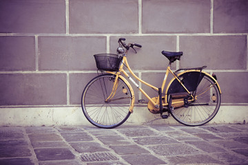 Fototapeta na wymiar Old bike against the wall - toned image