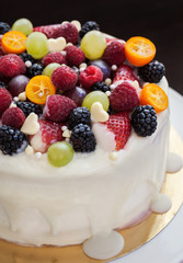 White chocolate cake decorated with fresh berries and fruits