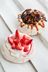 Two different versions of Pavlova meringue cake