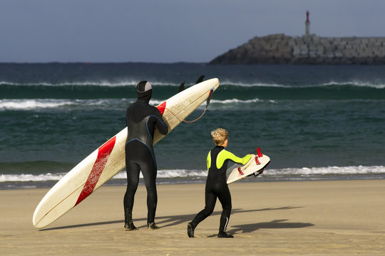 boy and man surfers waiting for the waves on Sabon beach Corunna