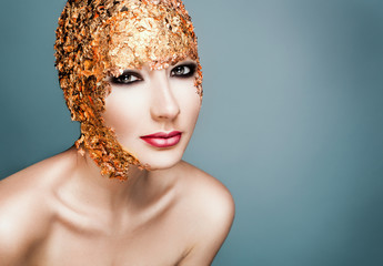 Close-up portrait girl model in a stylish gold foil.