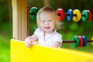 Fototapeta na wymiar Toddler girl having fun at a playground