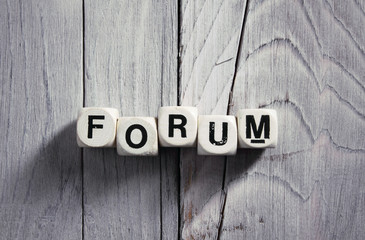 Forum. Blocks on wooden background. Vintage style.