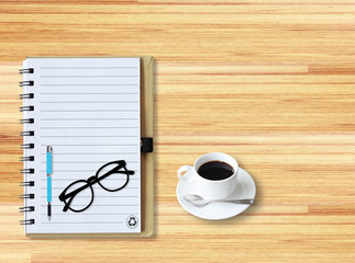 Notebook with office supplies with pen with glasses and cup of c
