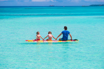 Fototapeta na wymiar Father and kids on surfboard during summer vacation
