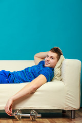 Young man fit body relaxing on couch after training