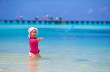 Little girl playing with flying disc at wnite beach