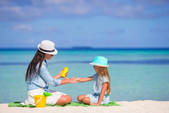 Young Mother Applying Sunscreen On Her Kid