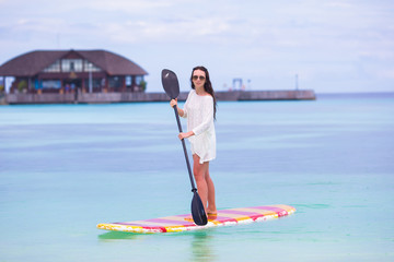 Active young woman on stand up paddle board