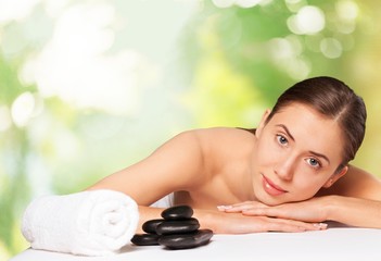 Fototapeta na wymiar Spa. Relaxed young female getting a stone massage in a spa
