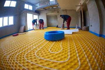 workers installing underfloor heating system