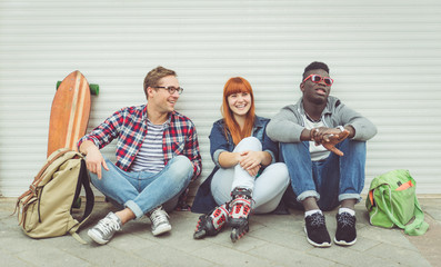 three mixed race friends sitting and having fun