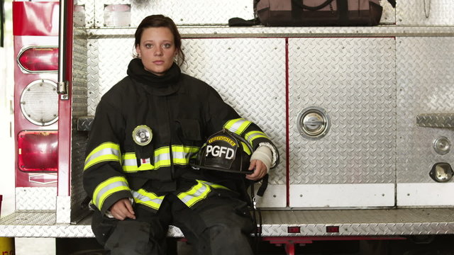 MS TU Portrait of female firefighters sitting at back of fire engine in garage, Pleasant Grove, Utah, USA
