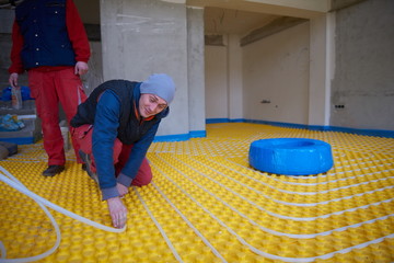 workers installing underfloor heating system