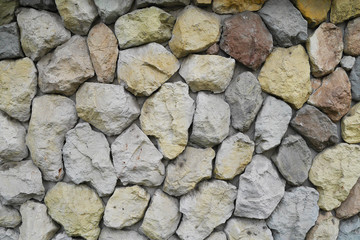 yellow, red, blue, stones and pebbles on gray wall, background,