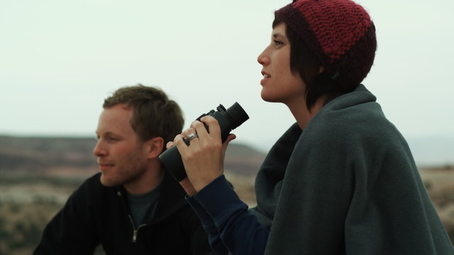 couple with binoculars in the desert