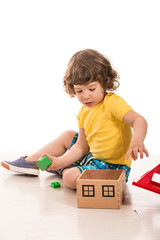 Toddler boy playing with wood house toy