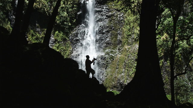 man with a camera at a waterfall