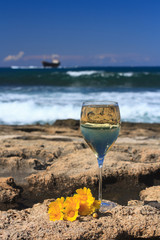 Fototapeta na wymiar White wine closeup on a background of the sea. vertical 