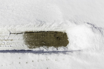 Car tire imprint in melt snow