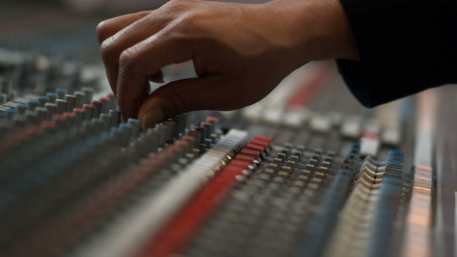 close up of hand on music studio panel