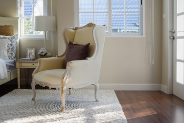 classic chair with brown pillow on carpet in vintage style bedro
